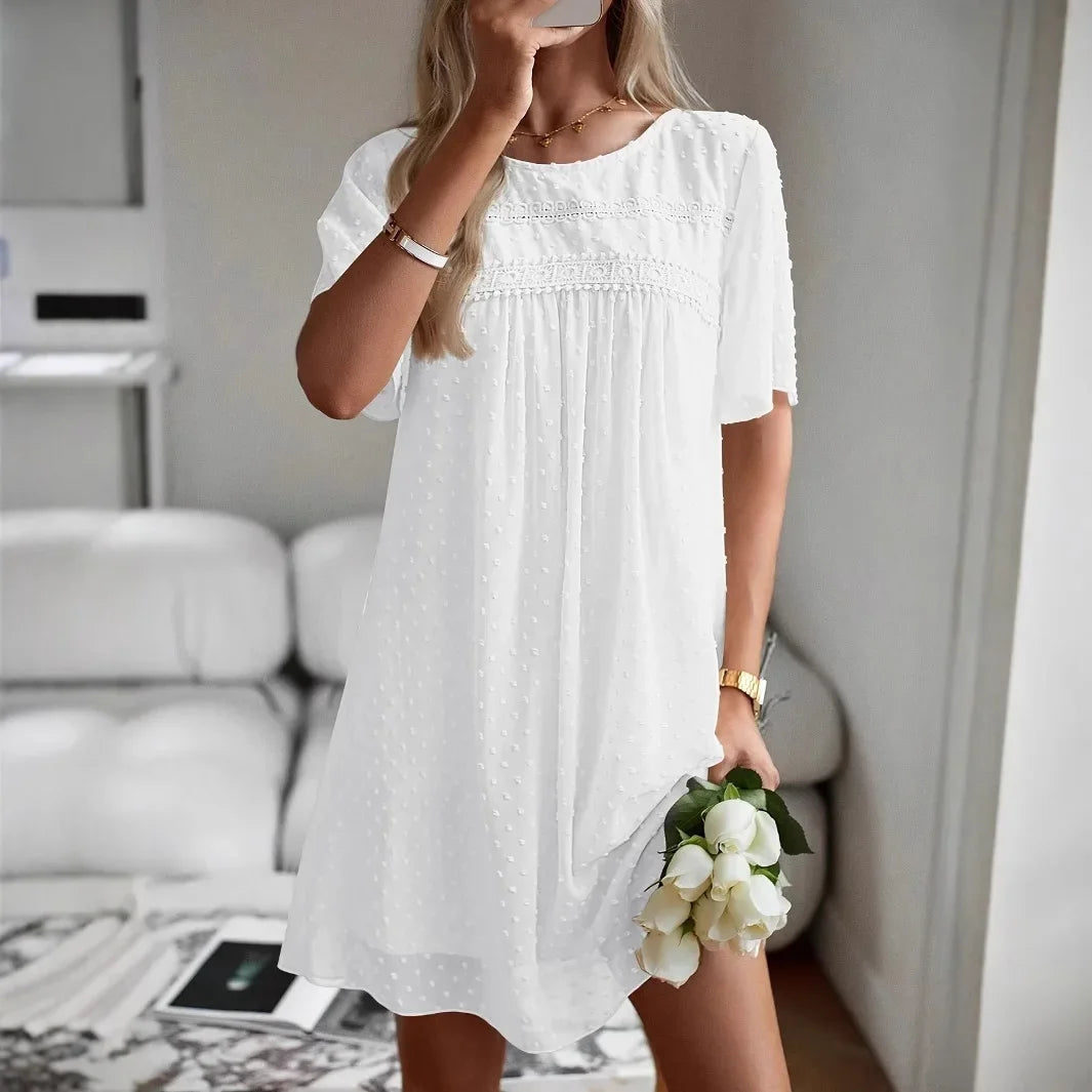 Frau trägt einfarbiges Kurzarmkleid am Strand