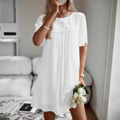 Frau trägt einfarbiges Kurzarmkleid am Strand